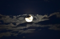 der Mond ist von dunklen Wolken umgeben